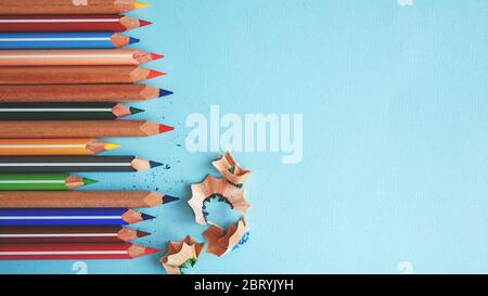 colored pencils and pencil shavings on blue background. Stock Photo