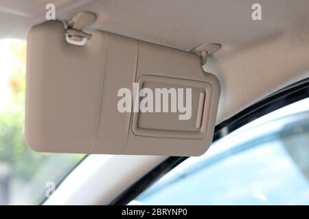 Sun visors prevent sunlight shining into the eyes while driving. Sun visors in the area in front of the car above. Stock Photo