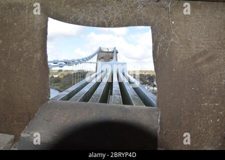 Looking out across the chains on the Menai Suspension Bridge over towards Anglesey Stock Photo