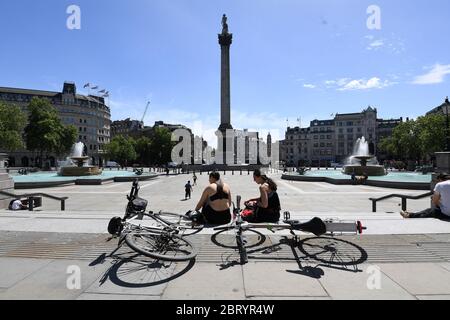 Cyclists take a break in the sunshine in Trafalgar Square, London, after the introduction of measures to bring the country out of lockdown. Stock Photo