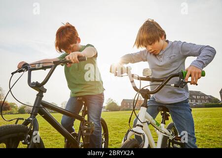 Two boys riding their BMX bikes in a park. Stock Photo