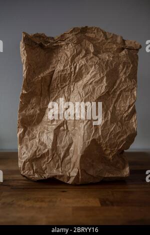 Close up of crumpled brown paper bag on grey background. Stock Photo