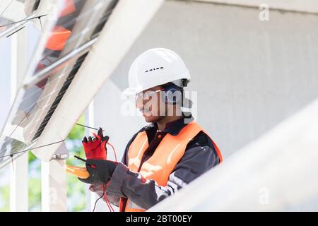 Male engineer wearing hardhat and ear protectors working on construction site. Stock Photo