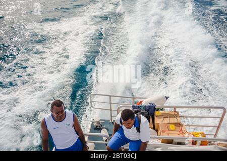 Fijian men standing on the ships stern. View from above on a cruise in fiji Stock Photo