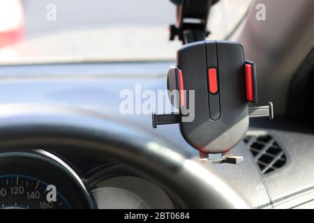 Mobile phone holder on the car for safety while driving a vehicle. Stock Photo