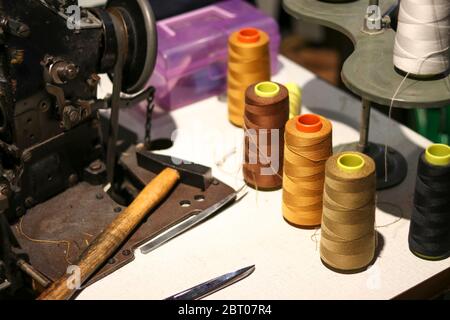 Polyester sewing thread spool placed on an ancient sewing machine. Stock Photo