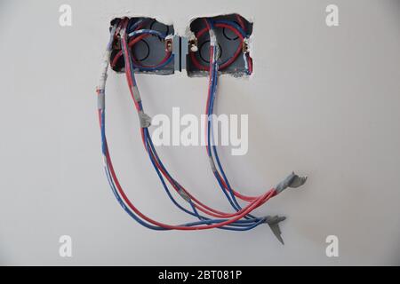 new electrical outlets in flat . Electrical wires, wiring, socket on an old concrete building wall, home repair . electric plug in home improvement Stock Photo