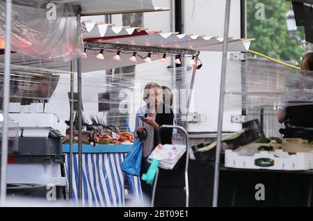 Paris, France. 22nd May, 2020. A woman is seen at an open air market in Paris, France, May 22, 2020. France has decided to organize the delayed second round of mayoral elections on June 28, which Prime Minister Edouard Philippe said on Friday is 'reversible' if the coronavirus epidemic situation turns against it. Credit: Gao Jing/Xinhua/Alamy Live News Stock Photo