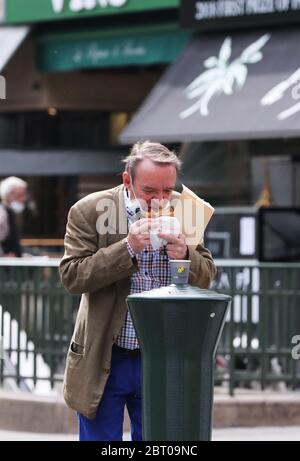 Paris, France. 22nd May, 2020. A man has his breakfast on a street in Paris, France, May 22, 2020. France has decided to organize the delayed second round of mayoral elections on June 28, which Prime Minister Edouard Philippe said on Friday is 'reversible' if the coronavirus epidemic situation turns against it. Credit: Gao Jing/Xinhua/Alamy Live News Stock Photo