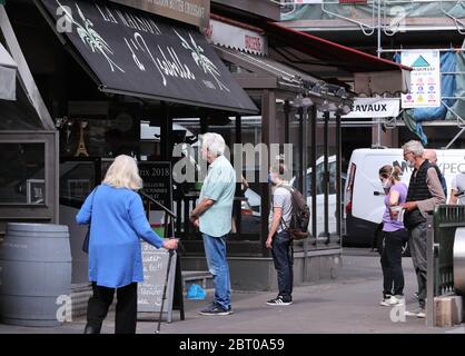 Paris, France. 22nd May, 2020. People queue outside a bakery in Paris, France, May 22, 2020. France has decided to organize the delayed second round of mayoral elections on June 28, which Prime Minister Edouard Philippe said on Friday is 'reversible' if the coronavirus epidemic situation turns against it. Credit: Gao Jing/Xinhua/Alamy Live News Stock Photo