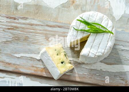 Bleu de Bresse is a French Blue cheese, from Bresse, here with mildew, top view on a wooden background. Stock Photo