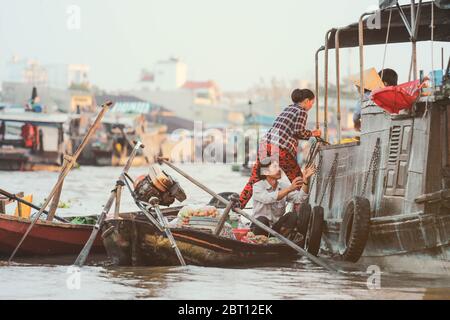 Mekong Delta - Vietnam - January 24, 2019 : Vendor selling vegetables on  Nga Nam floating market in Mekong Delta Vietnam. Stock Photo