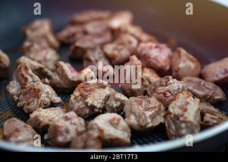 Close up of meat beef cubes chunks in a frying pan. Preparing dinner concept Stock Photo