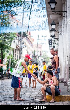 A happy Filipino man jokes with friends in the old walled  city of Intramurous, Manila , The Philippines. Stock Photo