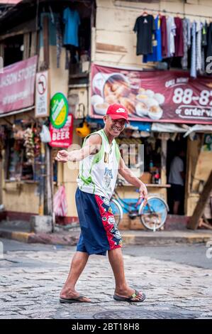 A happy Filipino man jokes with friends in the old walled  city of Intramurous, Manila , The Philippines. Stock Photo