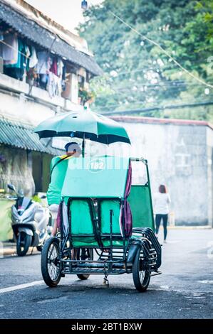 A traditional pedicab or rickshaw makes it way through the streets of the old walled city of Intramuros Manila, The Philippines. Stock Photo