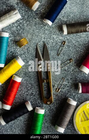 Sewing set concept with needles, spools and tools for crafting on grey concrete background with copy space Stock Photo