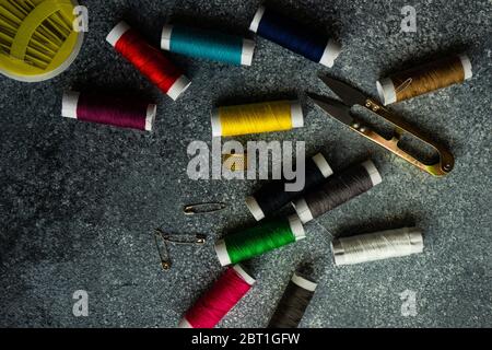 Sewing set concept with needles, spools and tools for crafting on grey concrete background with copy space Stock Photo