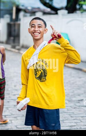 A young Filipino guy jokes with friends in the old walled city of Intramurous, Manila , The Philippines. Stock Photo