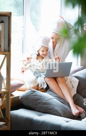 Mother and daughter, sisters have quite, beauty and fun day together at home. Comfort and togetherness. Concept of childhood, happiness, family's weekend, friendship, pajamas party. Domestic lifestyle.