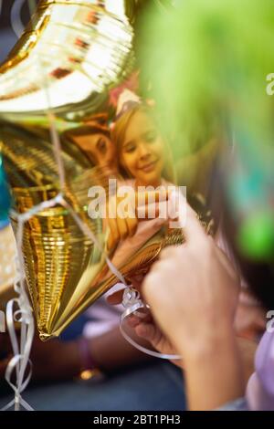 Reflection on birthday balloon happy little girl. Stock Photo