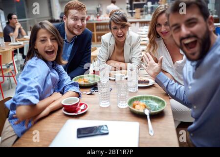 group of young adults having fun at lunch in restaurant, taking selfie Stock Photo