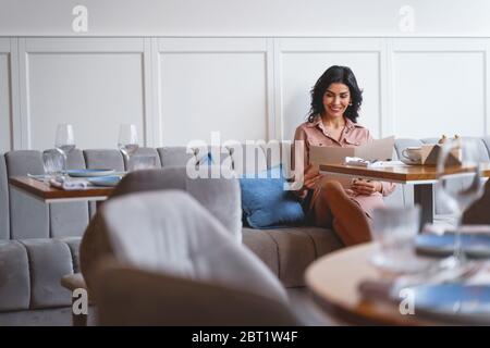 Cheerful young woman reading menu in restourant Stock Photo