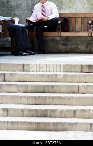 Two businessmen having meeting on park bench outside Stock Photo