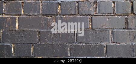 Old brick wall painted in black texture closeup Stock Photo