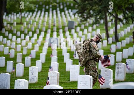 Arlington, United States Of America. 21st May, 2020. Arlington, United States of America. 21 May, 2020. Soldiers with the 3d U.S. Infantry Regiment, wearing PPE, place flags at headstones during Flags-in ceremony at Arlington National Cemetery marking the start of the Memorial Day holiday May 21, 2020 in Arlington, Virginia. Credit: Elizabeth Fraser/DOD/Alamy Live News Stock Photo