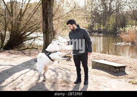A man playing with a dog, Jamie, outdoors on a cold day Stock Photo