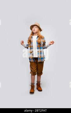 cute long-haired emotional girl in traveler clothes explores something Stock Photo