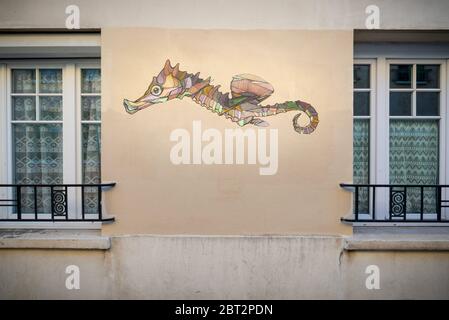 Paris, France - May 17, 2020: Detail view of a mural showing a seahorse painted on an apartment building,, taken at the end of the day, Butte-aux-Cail Stock Photo