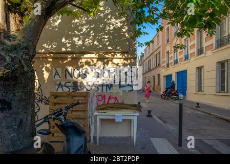 Paris, France - May 17, 2020: Graffiti saying 'to our murdered sisters', with a woman passing by, taken at the end of the day, Butte-aux-Cailles Stock Photo
