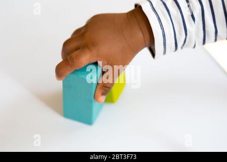 One year old baby boy playing with colorful building wooden blocks on table Stock Photo