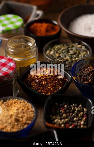 Different shape of bowls in different kind of spices on a wooden table Stock Photo
