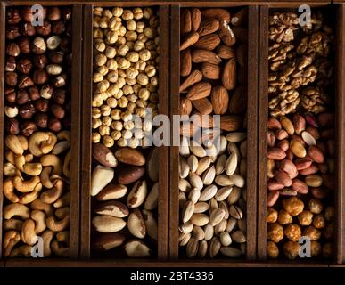 Mix of nuts in a wooden box on a wooden surface Stock Photo