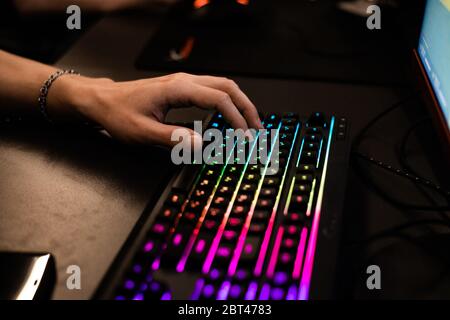 Home gamer plays backlit keyboard Stock Photo