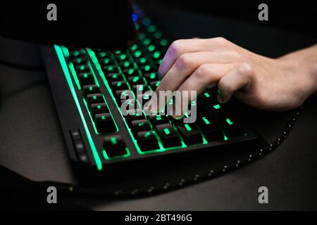 Home gamer plays backlit keyboard Stock Photo