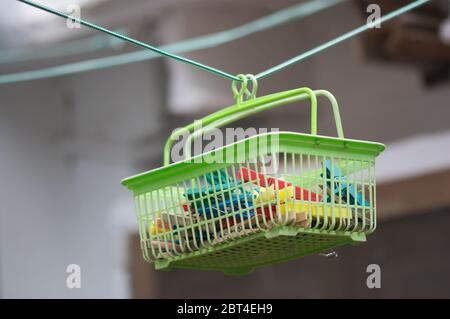 A basket for clothespins suspended from the thread where the clothes are hung for drying in the sun Stock Photo