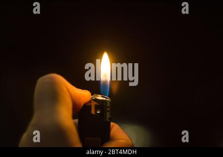 Hand Igniting Cigarette Lighter Isolated On Black Background Stock Photo