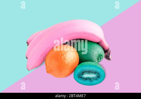 Pink bananas, blue kiwi and red lemon still life, on pink and blue background. Flat lay Stock Photo