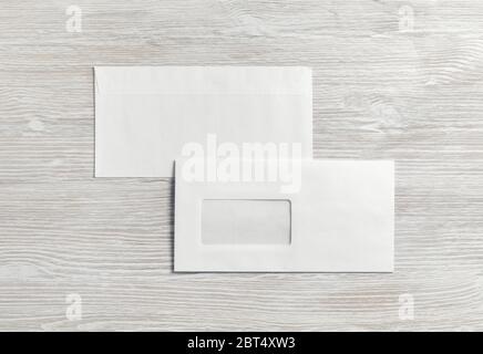 Photo of two blank paper envelopes on light wooden background. Back and front. Flat lay. Stock Photo