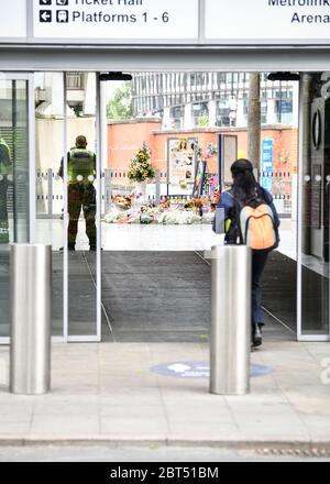 A view of a memorial with flowers, cards, and photographs during the commemoration.People gather at Victoria station to mark the third anniversary of Manchester Arena terror attack despite lockdown. Stock Photo