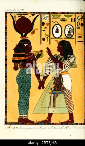 Figure of the Egyptian goddess Hathor with King Seti I from his tomb in Thebes, discovered by Giovanni Battista Belzoni. She holds his hand and offers her menat necklace as protection. Handcoloured copperplate engraving from Giulio Ferrario's Costumes Ancient and Modern of the Peoples of the World, Florence, 1834. Stock Photo