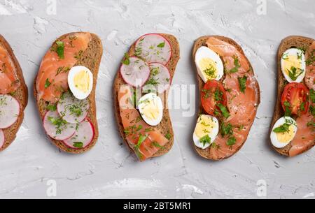 quail eggs sandwiches on gray chalkboard. flat lay composition. Stock Photo