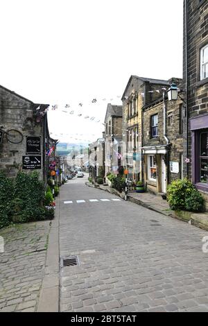 The view looking down the cobbled main street in Haworth, West Yorkshire.  Haworth was home to the Bronte sisters and is a popular tourist destination Stock Photo