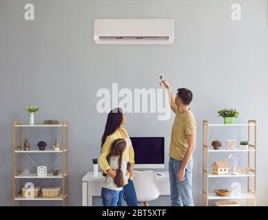 The family uses air conditioning at home. Back view. Climatic air system in the living room. Stock Photo