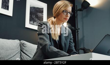 Businesslady working laptop on sofa Stock Photo