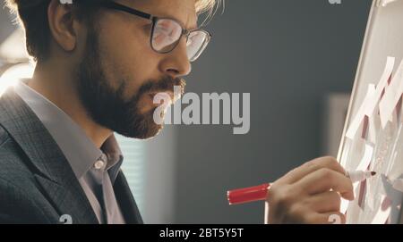 Businessman writing on whiteboard Stock Photo